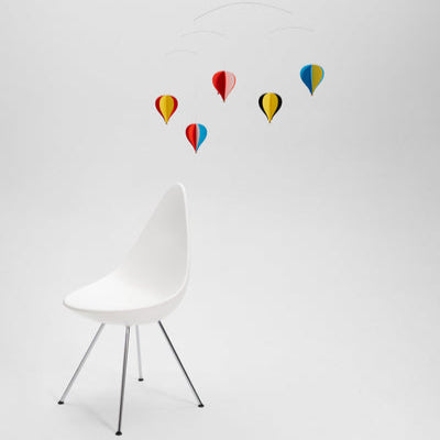 White chair with colorful balloon decals on a light gray background