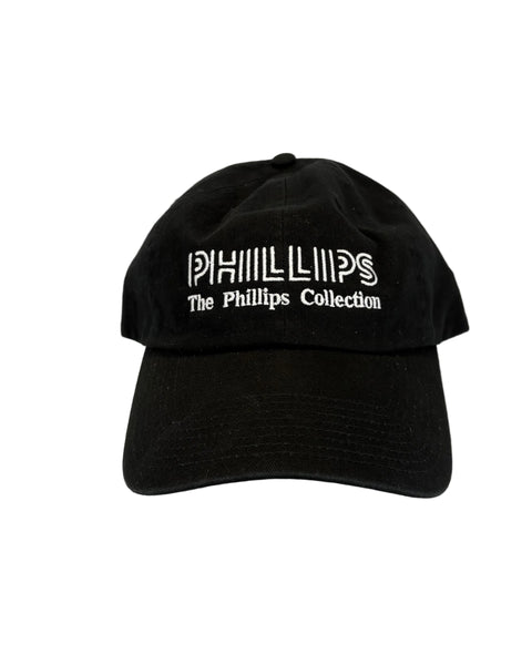 A black baseball cap with white embroidered text reading 'PHILLIPS The Phillips Collection' on the front, photographed against a plain light background.